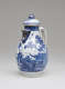 A white and blue chocolate pot with a spout, handle, and lid, the edges of the lid and spout are gilded. The decorations mainly depict floral, architectural, and landscape elements.