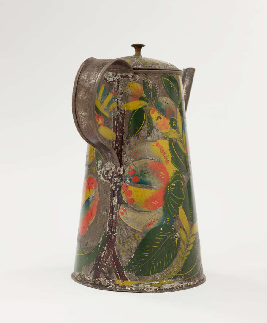 A tin coffee pot with painted orange, yellow, and green floral decorations.
