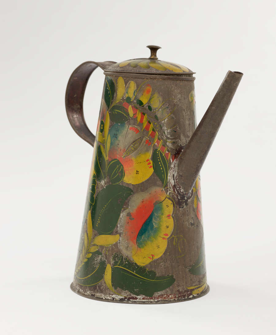 A tin coffee pot with painted orange, yellow, and green floral decorations.