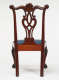 Rear view of a wooden chair with an intricately carved back and an upholstered blue seat supported by slender legs.