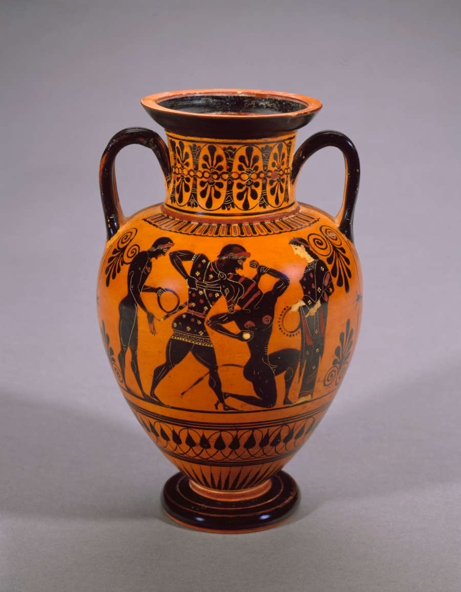 Terracotta onion-shaped jar with two black arched handles and black stripes, decorated with floral and geometric patterns and illustrations of a wheelchaired man amongst two women.