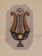 Stylized lyre motif which is yellow in the top half and black in the bottom with detailing throughout. There is a sunburst emblem above the strings.