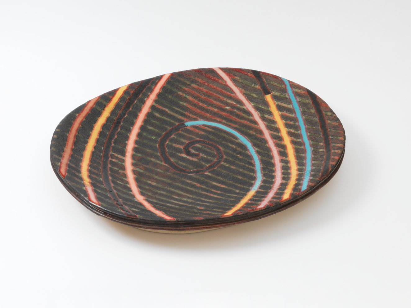 An oval, and shallow brown platter with vertical, woodgrain-like patterning overlaid with brightly colored spirals and lines in pink, yellow and turquoise.