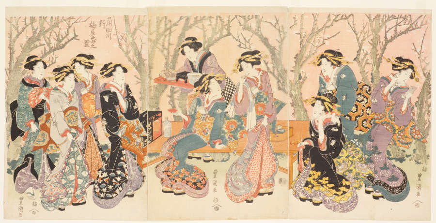 Woodblock triptych of ladies dressed in luxurious, colorful patterned garments gathering around a table with various food and drinks. Behind them are blossoming plum trees overtop a light pink background.