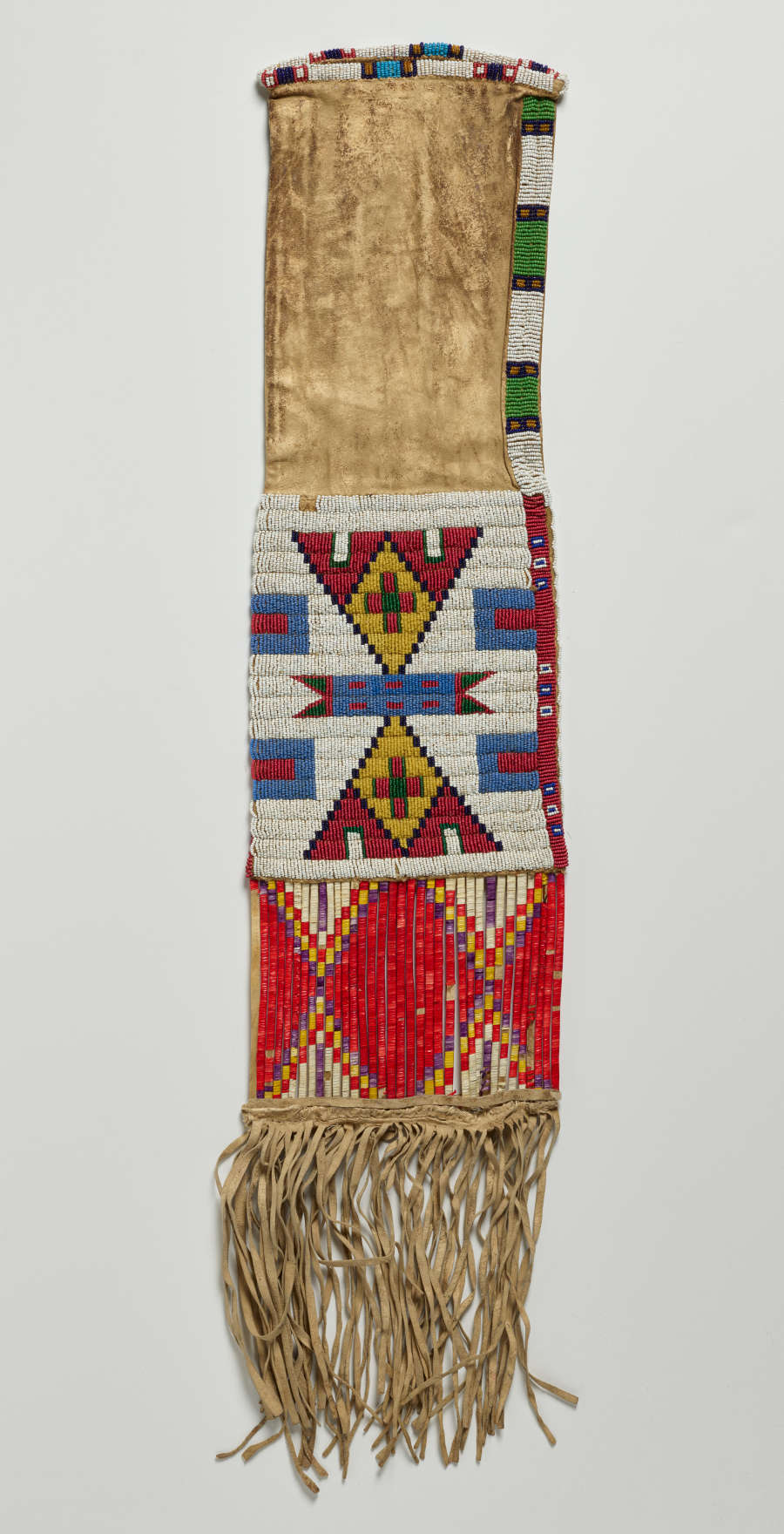 Back of a long velvety deerskin case, decorated with blocks of colorful geometric patterns in the lower half and similar borders along its upper sides. Tassels hang from the bottom edge.