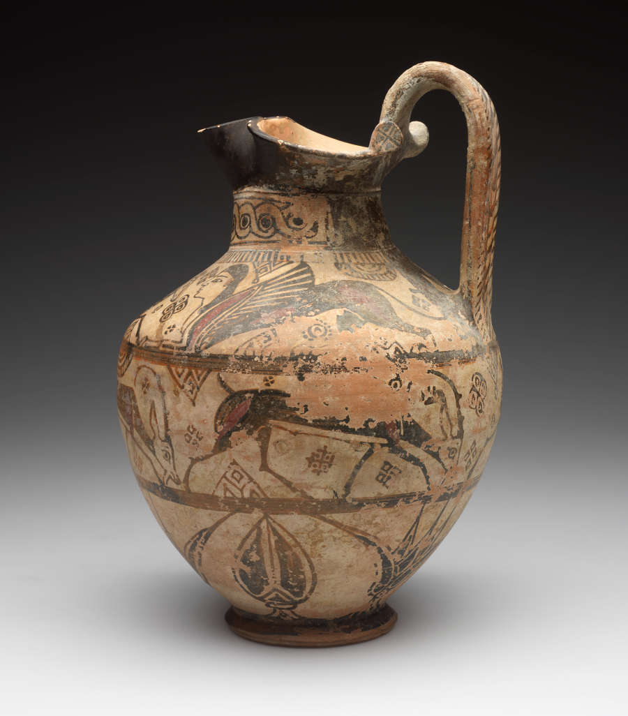 Side-view of an onion-shaped jug with a flared black mouth and long arched handle, decorated with three bands of floral and animal illustrations. The neck is patterned.