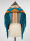 Back of a colorful woven fabric with fringe and geometric patterning draped around a mannequin. The mainly turquoise fringed ends are specially  brown, cream, and orange in the center back.