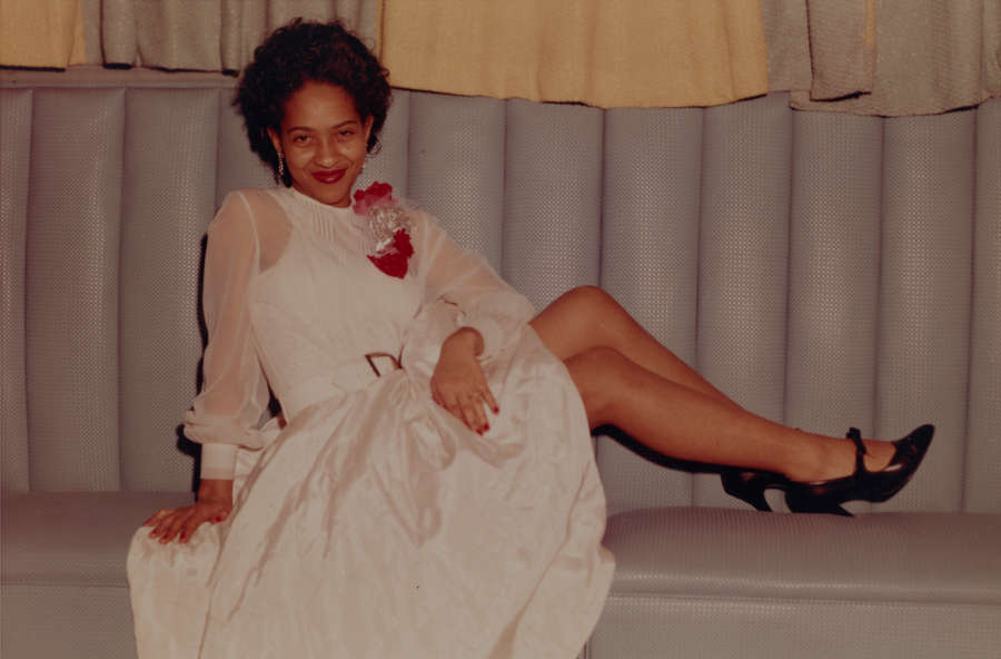 Color snapshot of a woman in a white dress on a grey sofa