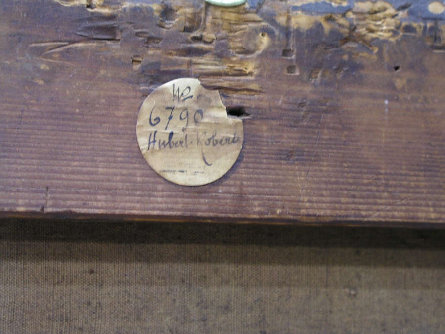 Close-up of a worn wooden frame with a round, aged label reading "No 6790 Hubert Robert".