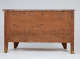 An image of the back of an antique wooden dresser. The wood is visibly aged with knots and grain patterns.