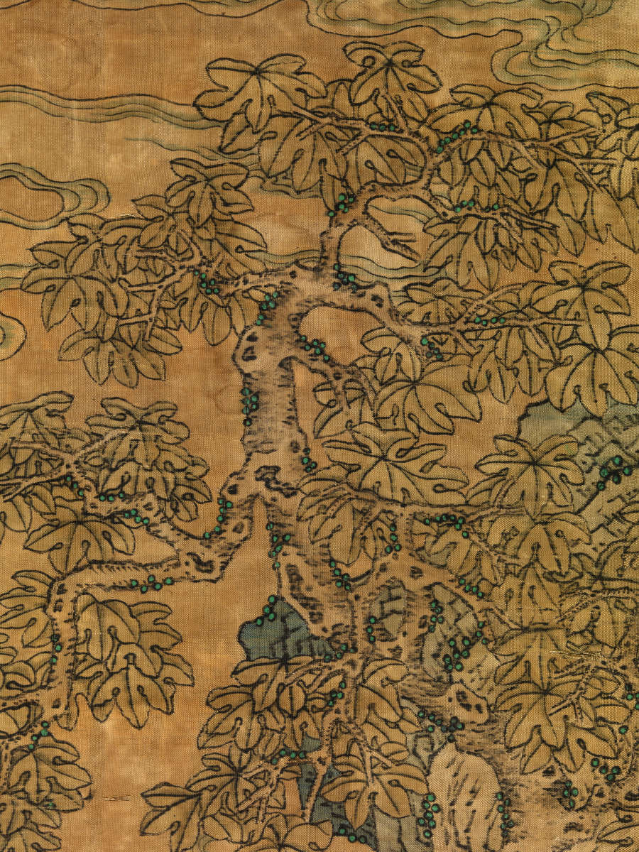 Detail of the scroll, showing a tree with intricate leaves amongst swirling clouds. The background is a faded dark yellow.