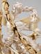 A silver figure with golden wings holds her wavy, tangled hair with one hand and a long gold garland aloft in the other hand with trumpet-blowing cherubs around her. 