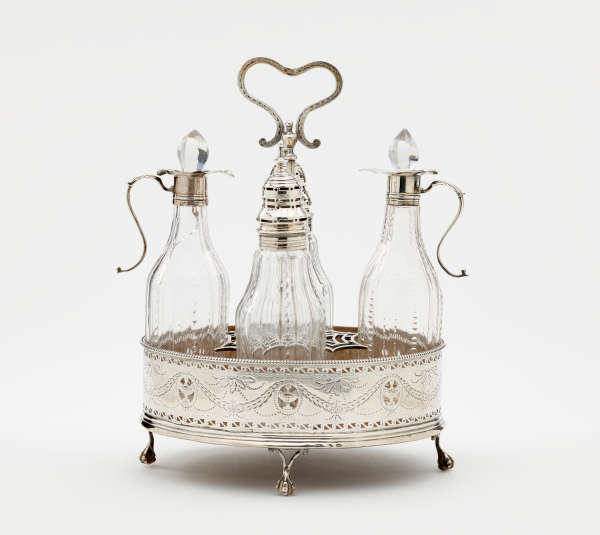 A silver container with small feet and a curved, open handle on top. Inside are several glass vessels with silver mounts.