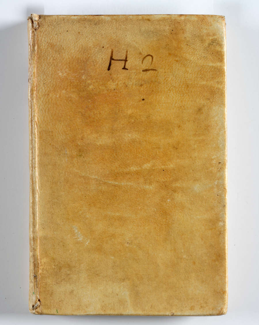 A worn book with a faded yellow cover marked by light stains and handwritten letters marked "H2" at the top.