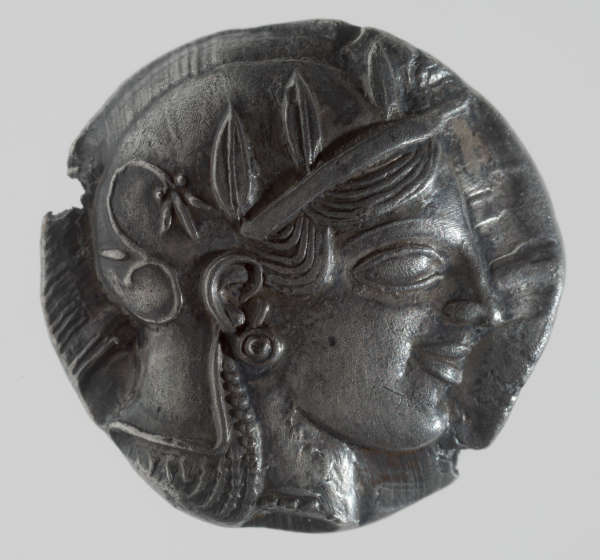 Silver coin featuring the profile of a head with a laurel crown, large earrings, and finely carved features.