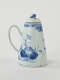 A white and blue teapot with floral decorations, a lid with a small semi spherical finial, spout, and a handle which is located approximately 90 degrees from the spout.