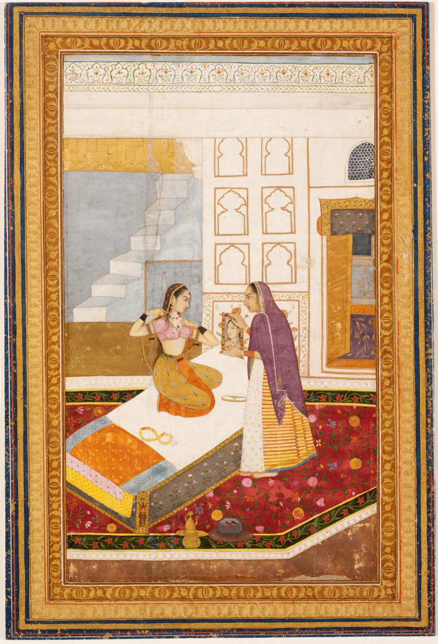 Delicate, highly detailed painting of one young woman sitting on a bed and a standing woman facing her. The rug, the bed, and other elements feature richly colored intricate patterns. 