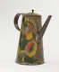 A tin coffee pot with painted orange, yellow, and green floral decorations.