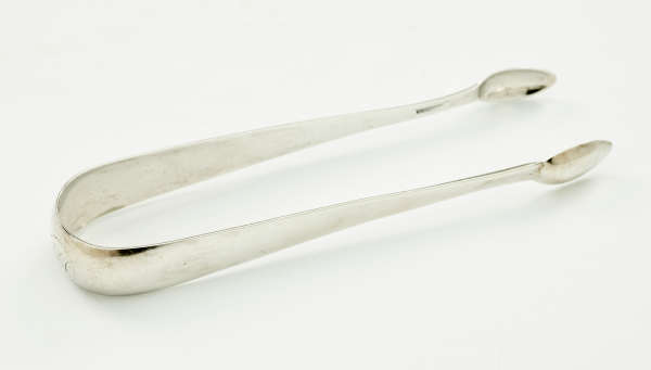 Silver sugar tongs with small ends and a thicker handle portion.
