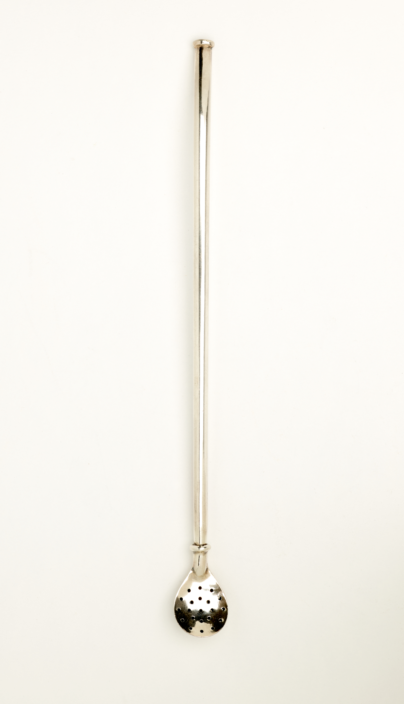 A silver utensil with a long handle and one end that is slightly larger and has small holes.