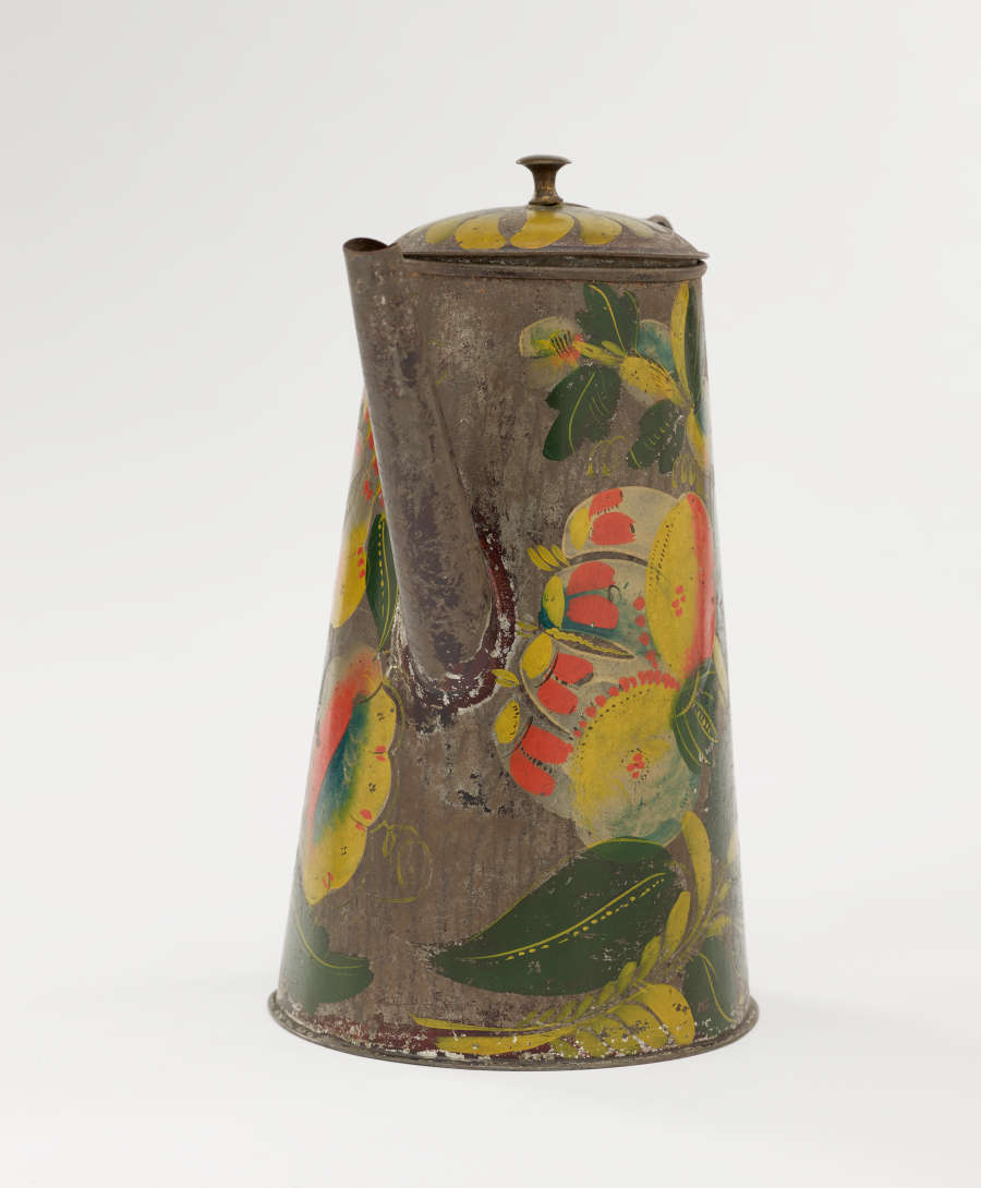 A tin coffee pot with painted orange, yellow, and green floral decorations.