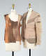Two dress forms with garments: a sleeveless top constructed of layered brown fabric and a beige, distressed jacket with exposed seams.