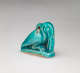 Turquoise amulet at an angle, of a crouching pelican-like bird with a long beak pointed downwards, head tucked into its neck, where there is a small loop.