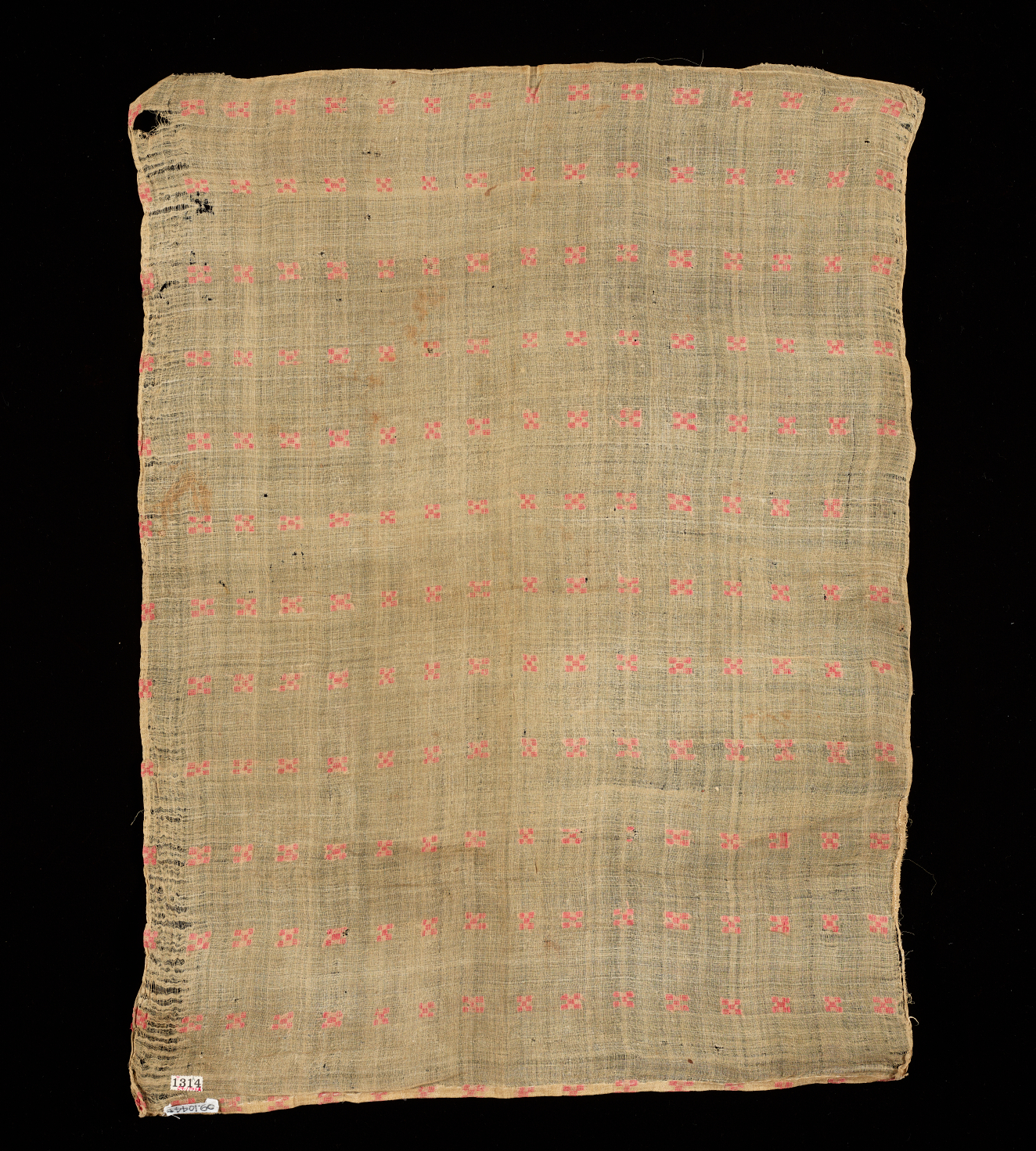 Rectangle of beige hand-woven fabric on a black background which has a grid of small pink stitched crosses across the surface. On the left edge are irregularities in the weave.