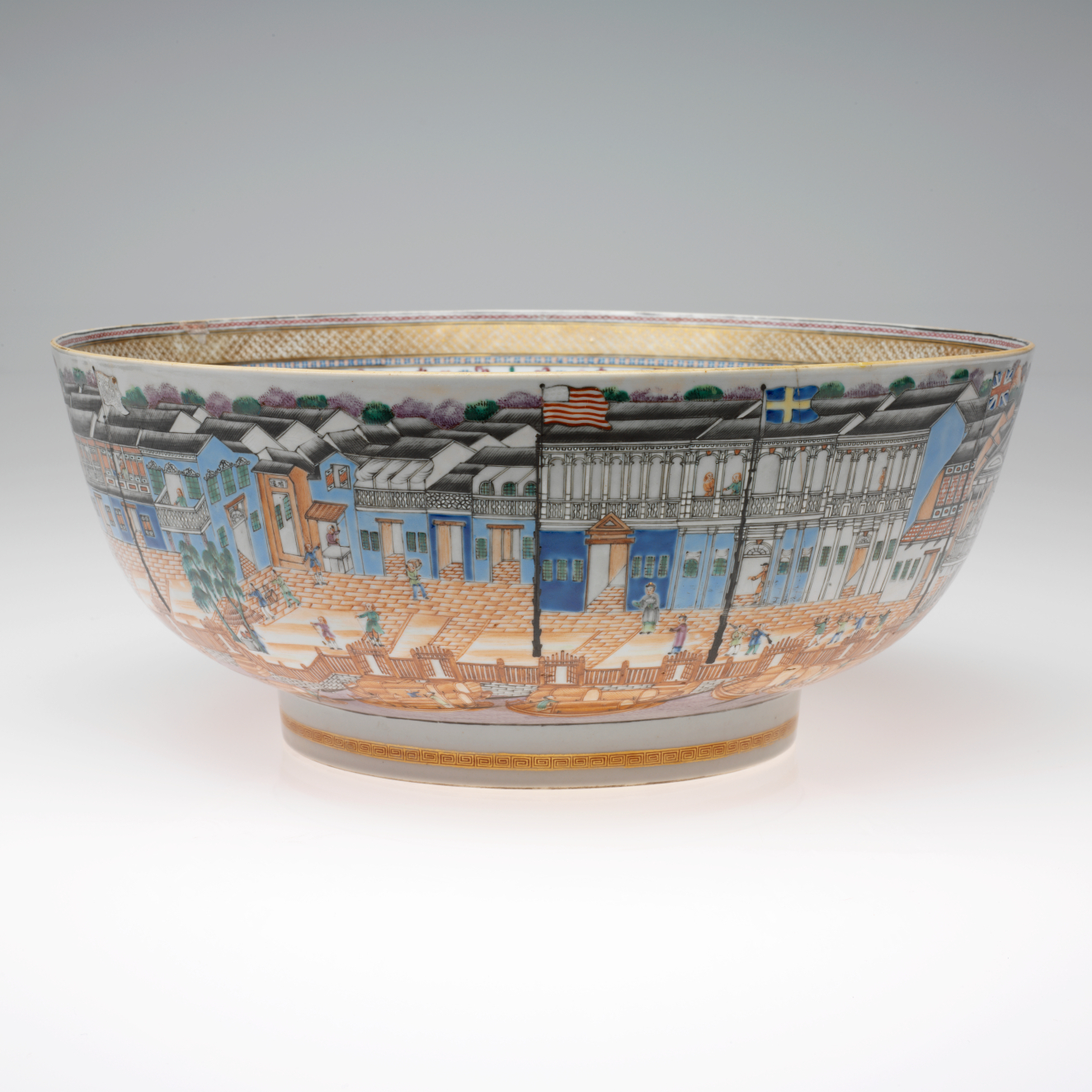 A ceramic bowl ornamented with a vibrant, bustling cityscape including buildings, figures, and boats in vivid colors and fine details. 