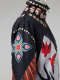 Side of the windbreaker on the mannequin, showing a pink, red, blue, and green beaded flower on the upper sleeve framed by white circles and red-orange feather motifs.