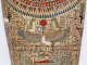 Painted coffin depicting a colorful winged human figure kneeling beneath a red sun with raised arms, bordered by hieroglyphs and decorative patterns.