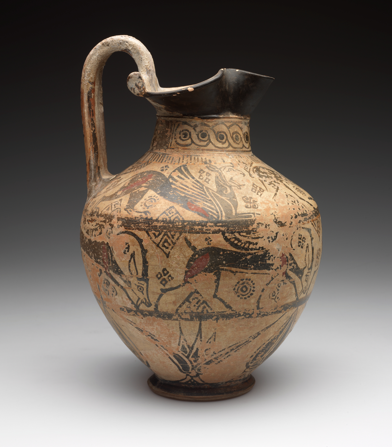 Side-view of an onion-shaped jug with a flared black mouth and long arched handle, decorated with three bands of floral and animal illustrations. The neck is patterned.