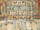 Close up of a coffin with horizontal bands of hieroglyphs painted in black.