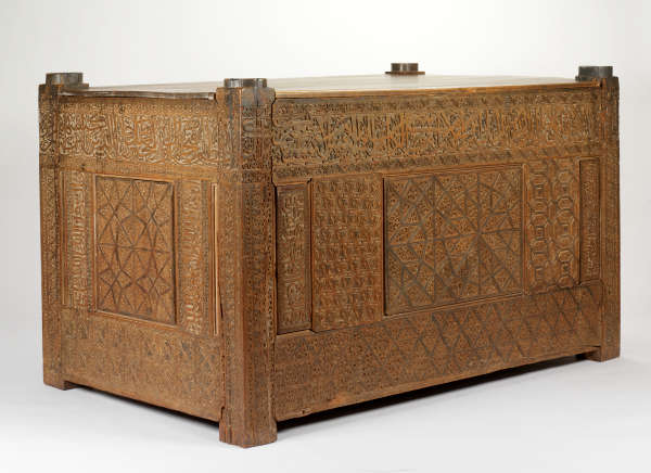 An intricately carved rectangular wooden chest with ornate geometric and floral carvings.