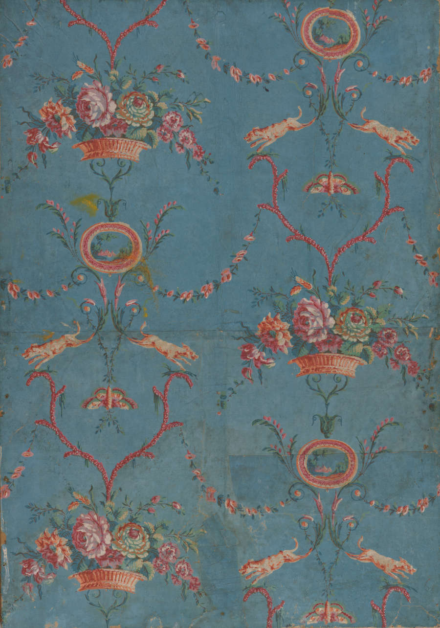 Segment of vintage repeating wallpaper featuring baskets filled with lush vibrant flowers and linking decorative garlands, on a faded and distressed blue canvas.