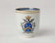 A cup with blue and gilded decorations along the outside and inside of the rim, body, and handle.