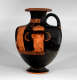 A tall terracotta vase with a deep black glaze, depicting two draped figures standing side by side, framed by orange decorative patterns along the neck and base.