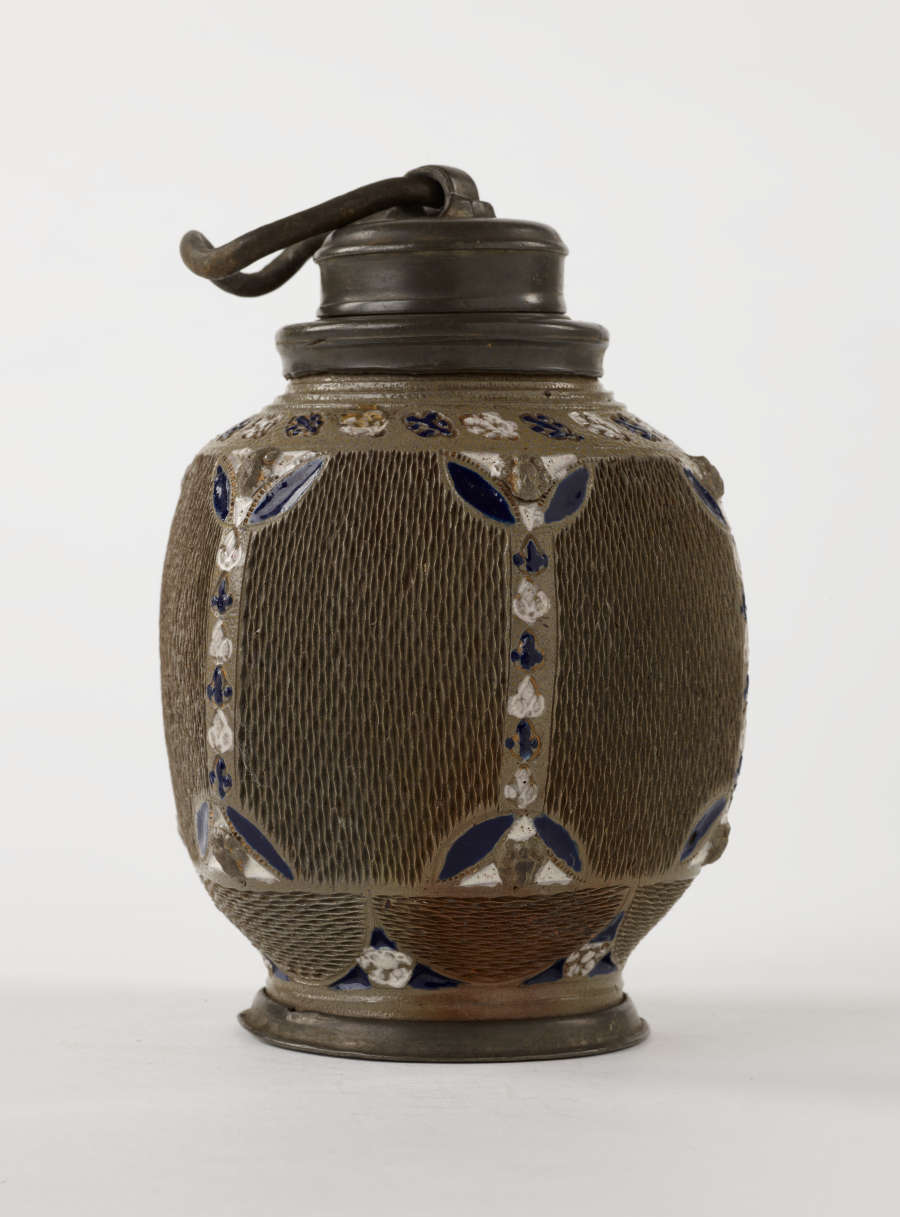 A flask that is dark gray, blue, and white. The body is angular and has textured sections whereas the foot and top are rounded.