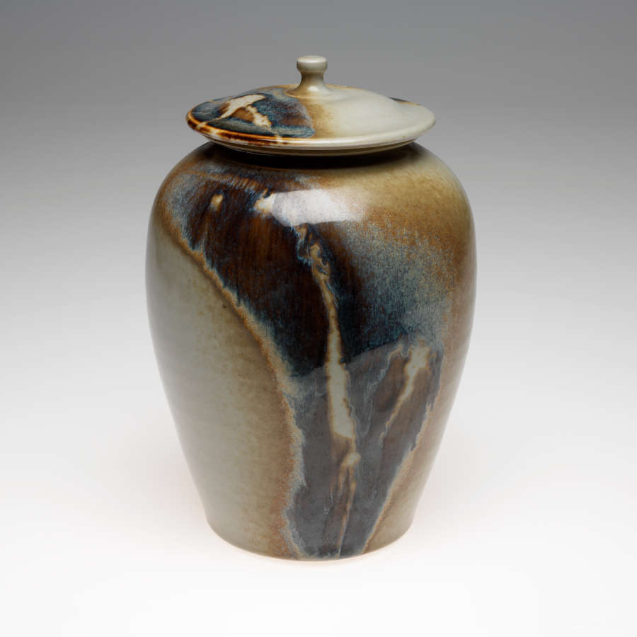 Lidded jar covered in shades of brown, blue, and cream