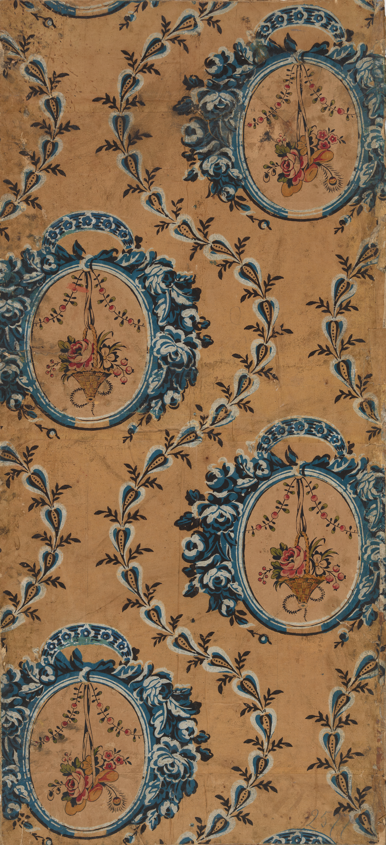 Aged wallpaper containing hanging floral bouquets within blue circular medallions against a pale orange background. Blue vine-like leaves curve around the medallions. 
