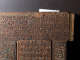 A close up of an intricately carved wooden corner with geometric patterns, including interlocking triangles filled with swirling carvings, bordered by floral motifs and calligraphy. 
