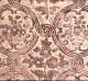 Close up segment of vintage wallpaper depicting a rustic pattern of brown florals and intricate swirl motifs on a beige, textured background.