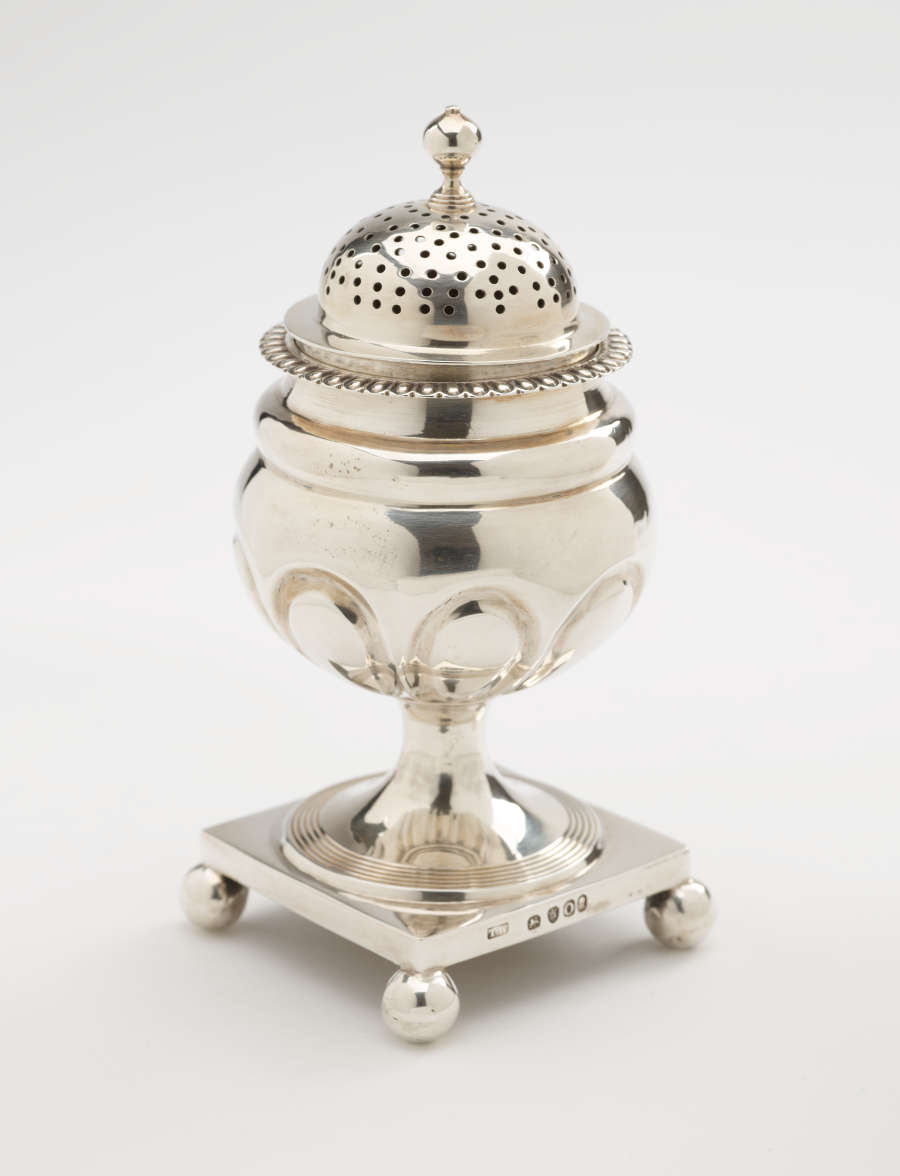  A silver caster with a square foot with small balls in each corner, the lid is perforated.
