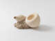 A sculptural piece with two cream-colored bulbous forms resting on a stone-like base.