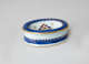 An oval white salt container with blue and gilded decorations.