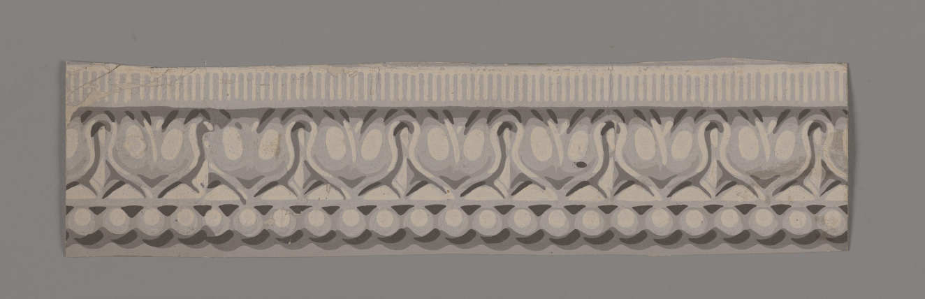 Ornamental border strip on a gray background featuring shaded small vertical stripes, symmetrical floral motifs and a beaded row along the bottom in shades of gray.