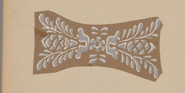 A decorative brown panel featuring a symmetrical white floral design with curved leaves and geometric patterns.