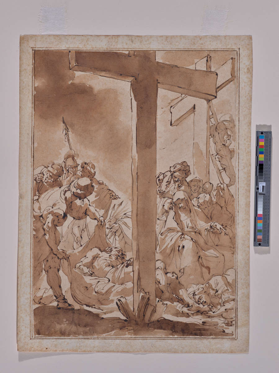 A pen and ink with brown wash drawing of Christ’s body being taken down from the Cross by his followers and Mary. The Cross is centered in the drawing.