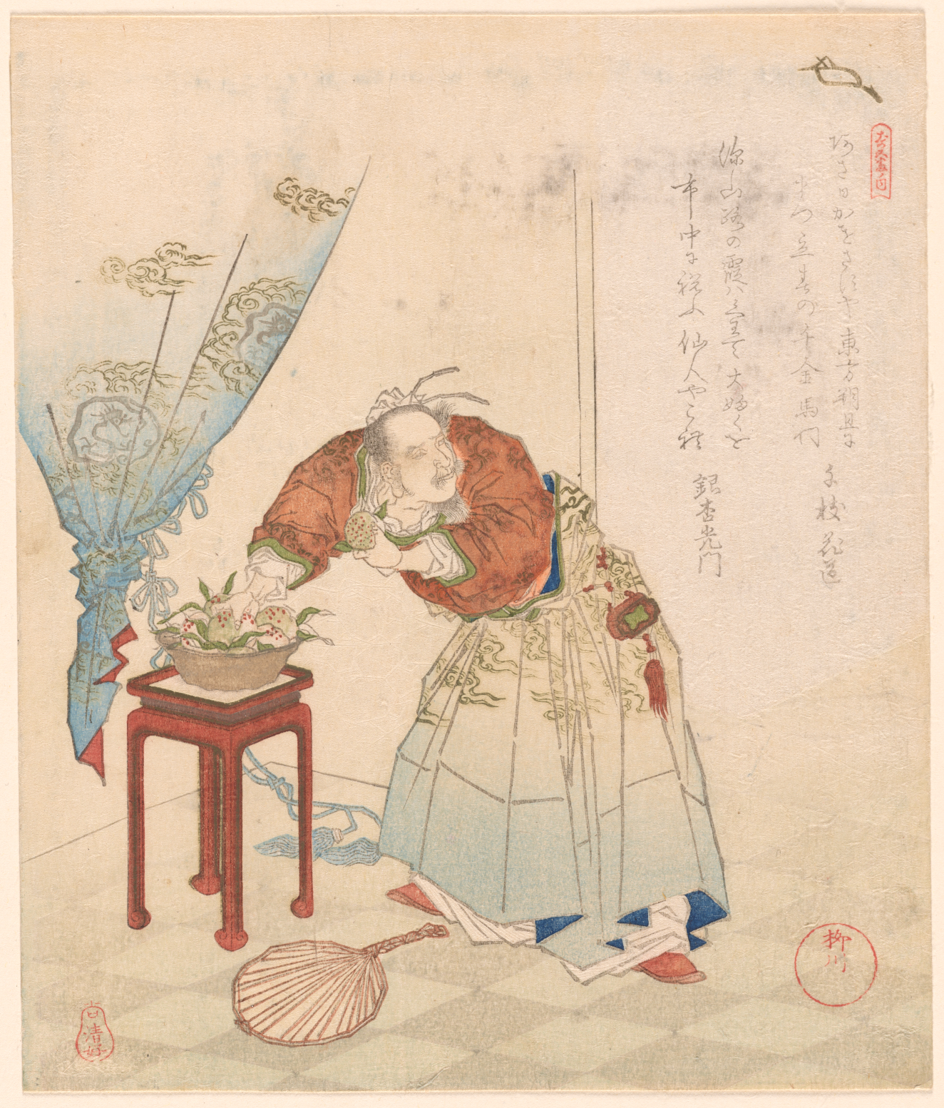 A robed man arranging flowers on a square table near sheer curtains.