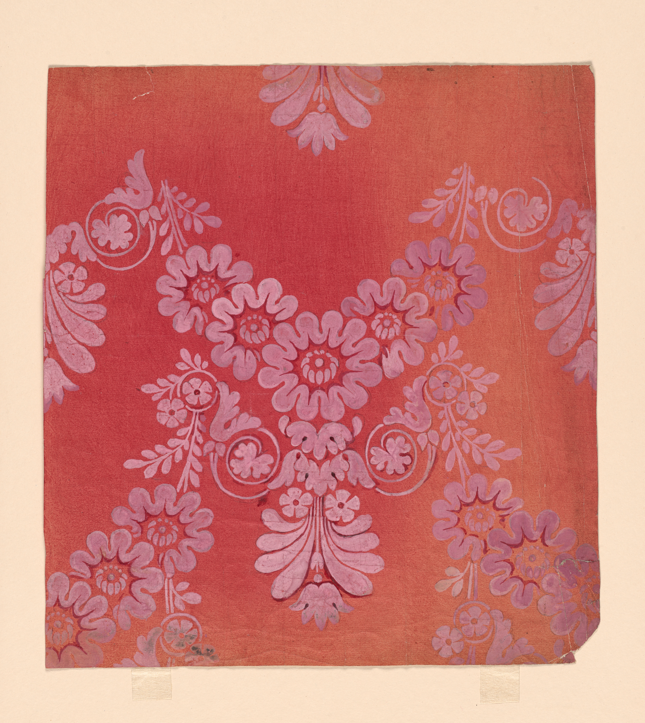 Wallpaper fragment of pale pink floral designs arranged symmetrically on a yellowing, red background.